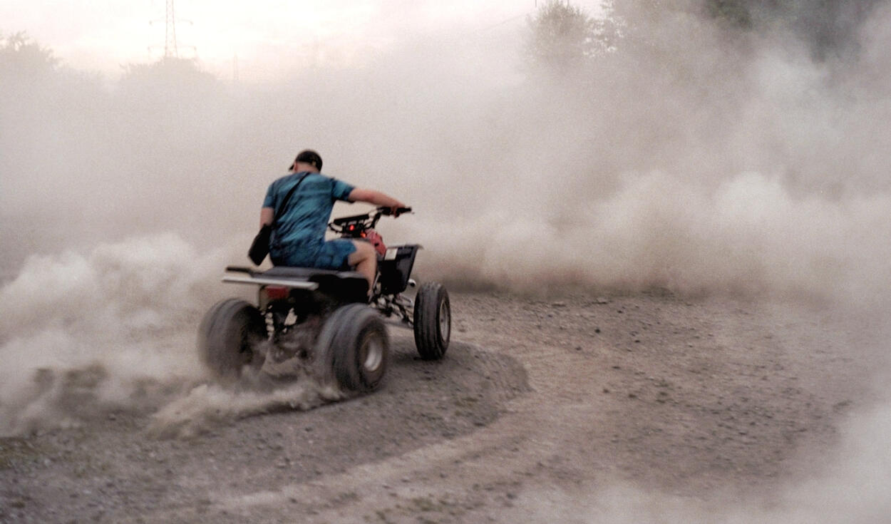 Rider kicking up dust on a quad bike