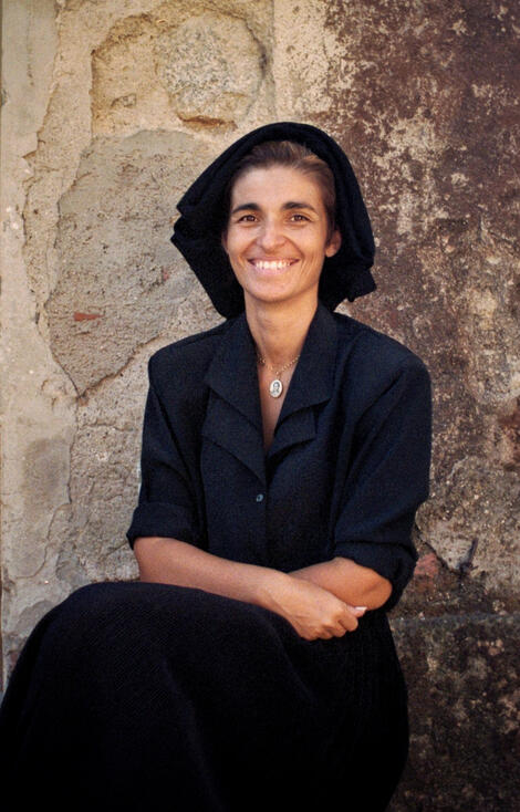 Woman in traditional Sardinian dress against an old wall
