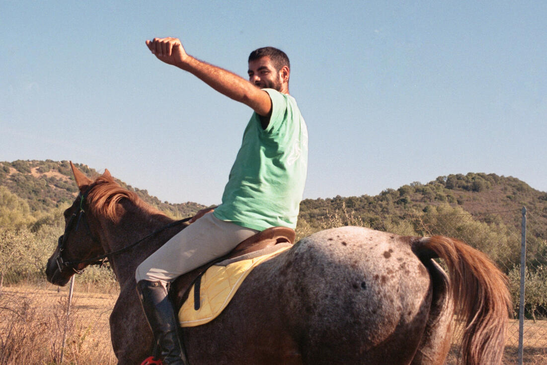 Horse rider raising his arm in the Sardinian hills