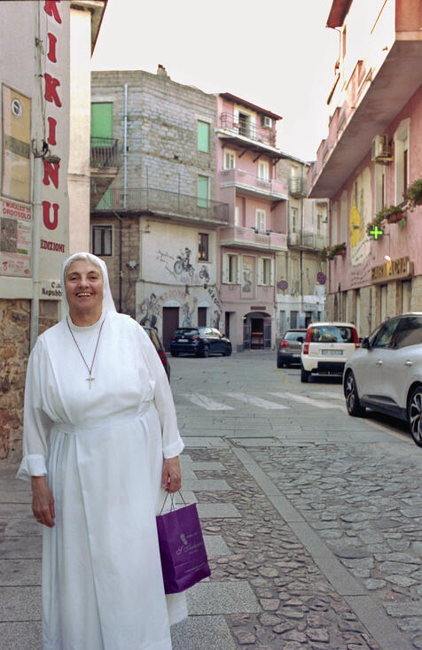 Nun in a white habit on a Sardinian village street