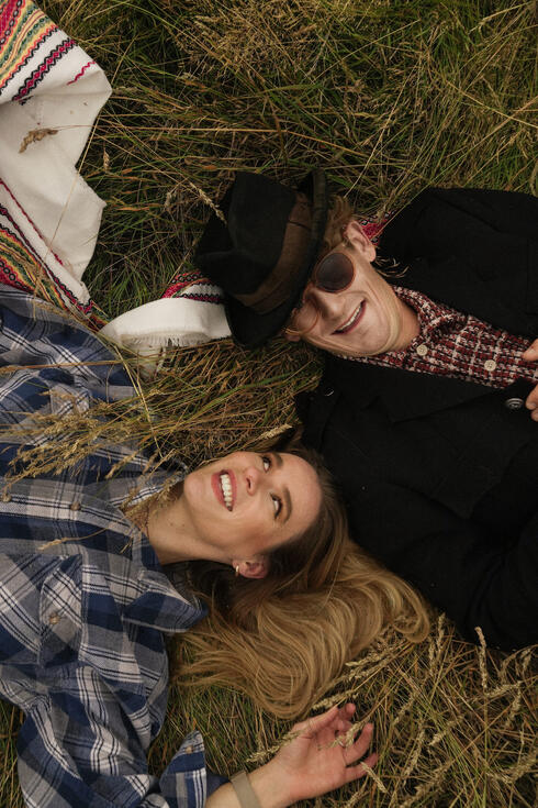 The Homburgs laughing together lying in a field