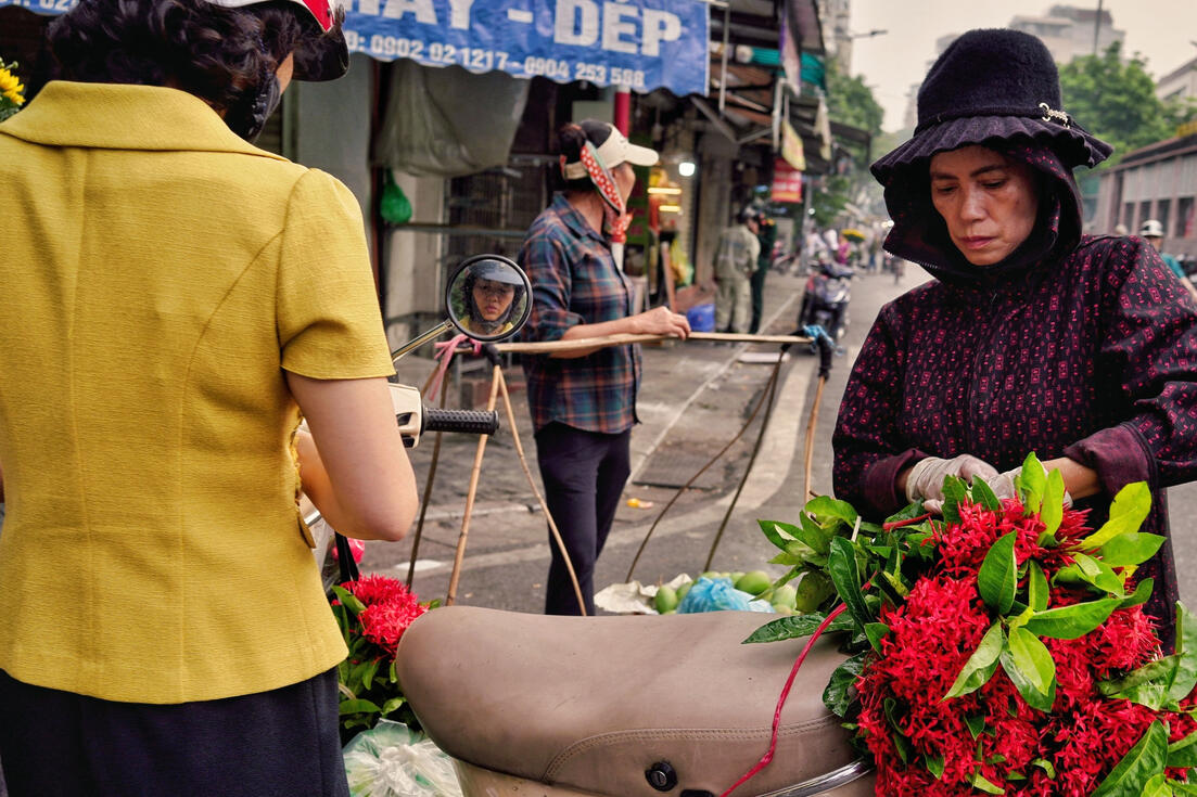 Flower vendors with laden bicycles on a Hanoi street