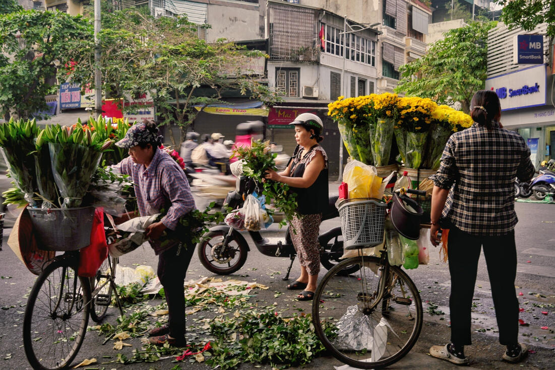Flower vendors with laden bicycles on a Hanoi street